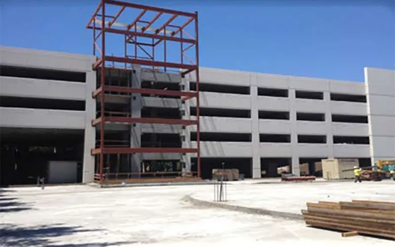 Stevens Creek Parking Garage: West elevation, large cladding panels on right. Steel stair tower in center.